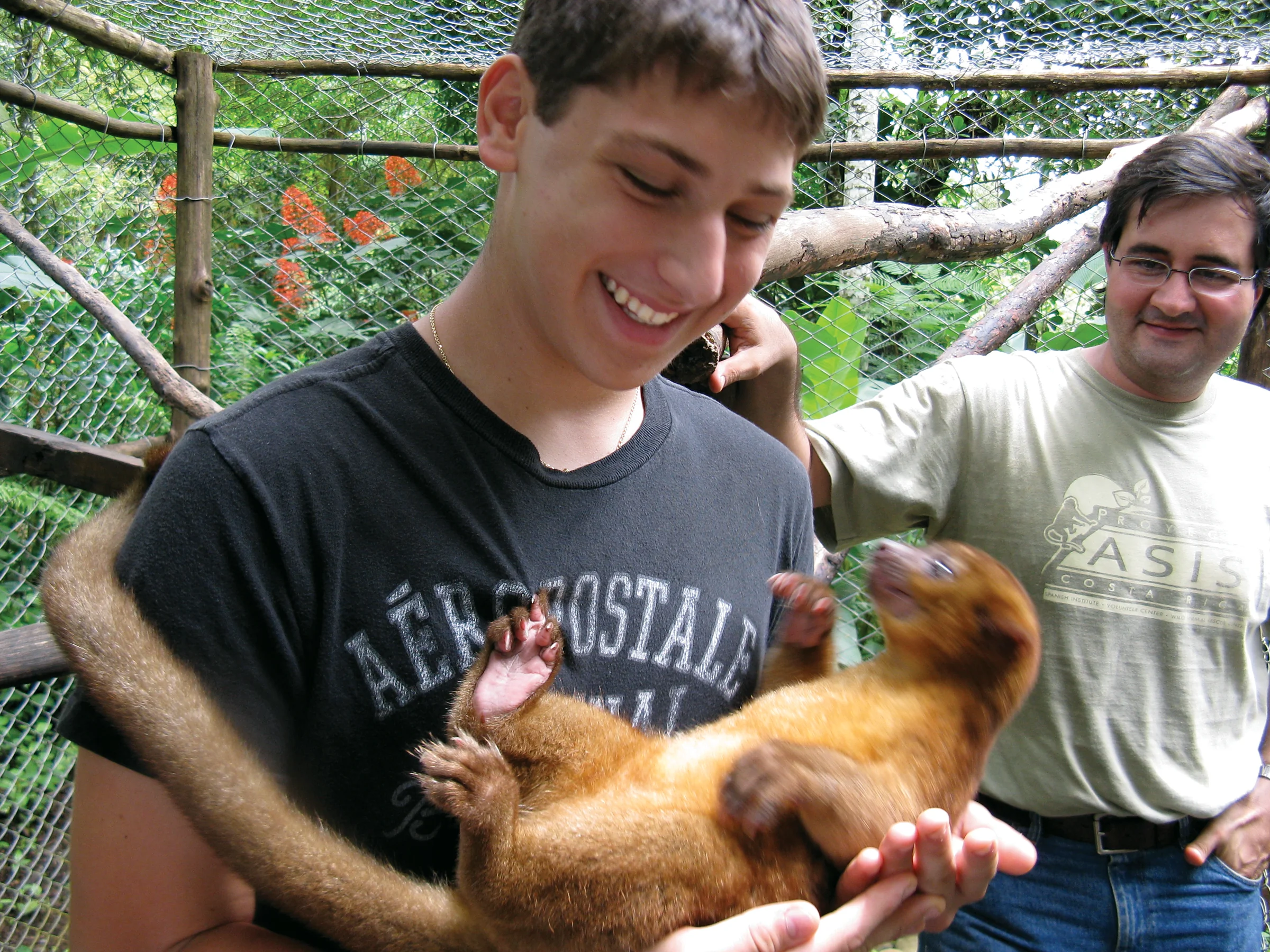 boy holding monkey in costa rica