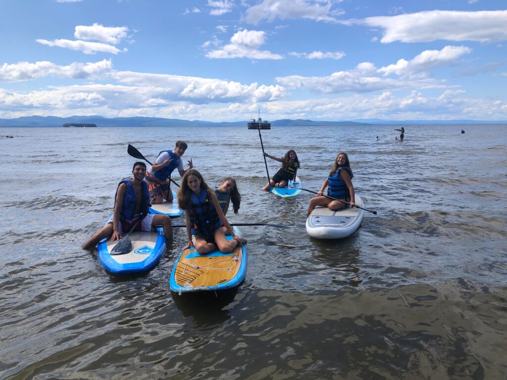 students paddle boarding on the lake