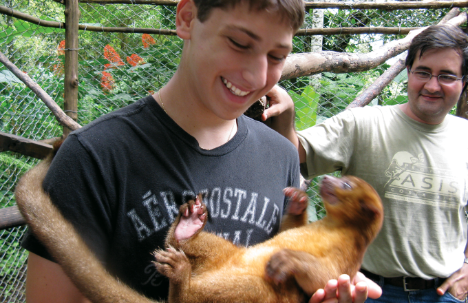 boy holding monkey in costa rica