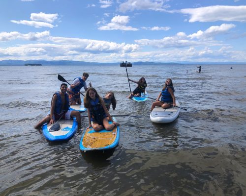 students paddle boarding on the lake