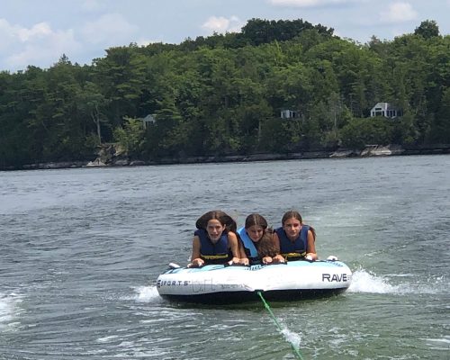 girls tubing on lake