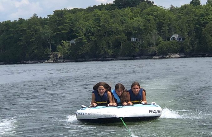 girls tubing on lake