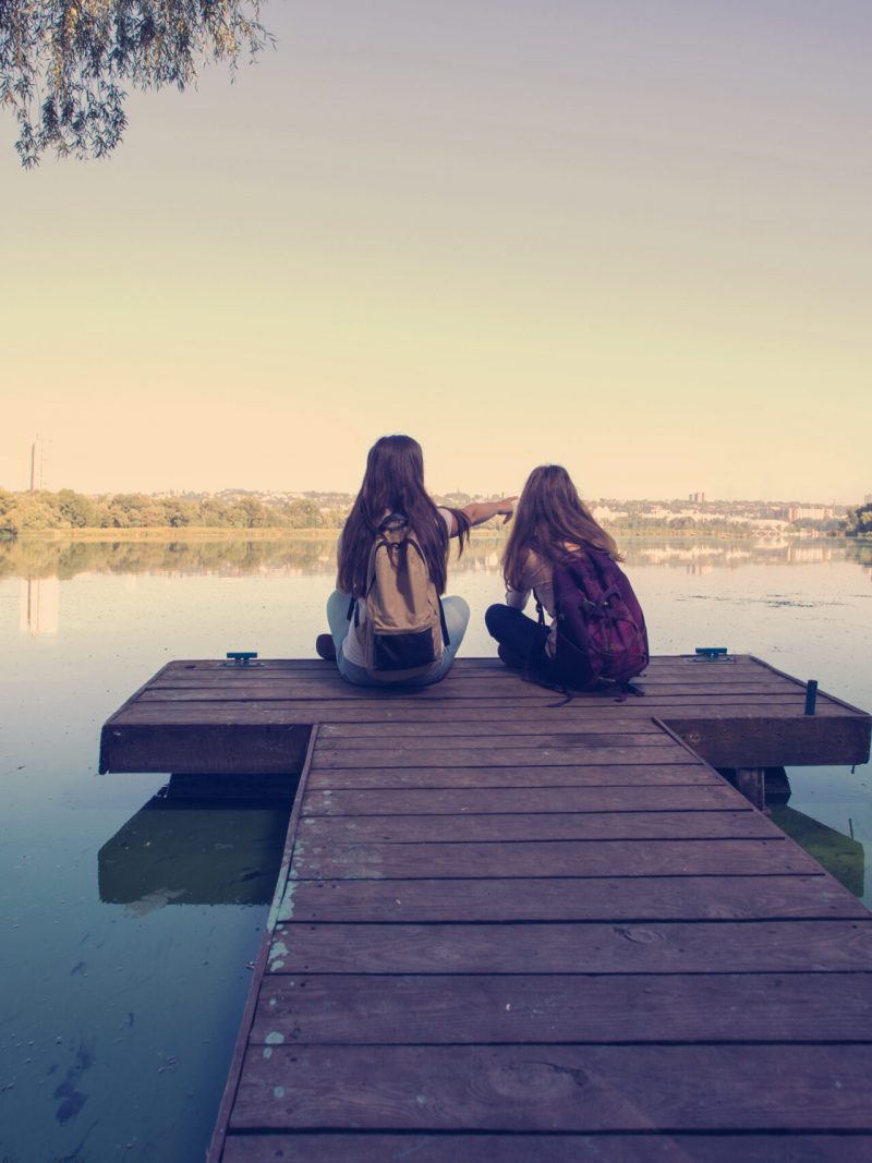 girls sitting on doc on Lake girls sitting on doc on Lake